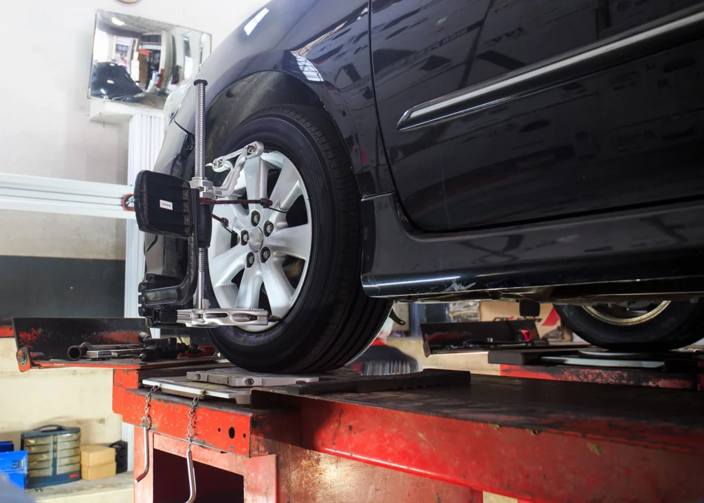 Car on stand with sensors on wheels for wheels alignment camber